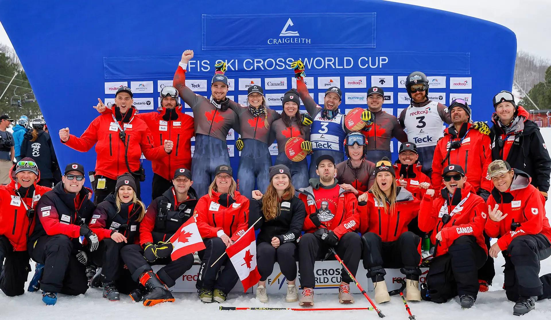 L'équipe Alpine Canada célèbre avec une photo de groupe devant la scène du podium